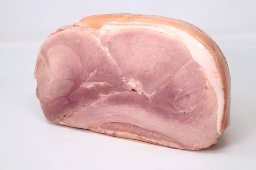 Fetta di prosciutto cotto su sfondo bianco.