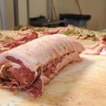Carne di maiale arrotolata su tavolo.