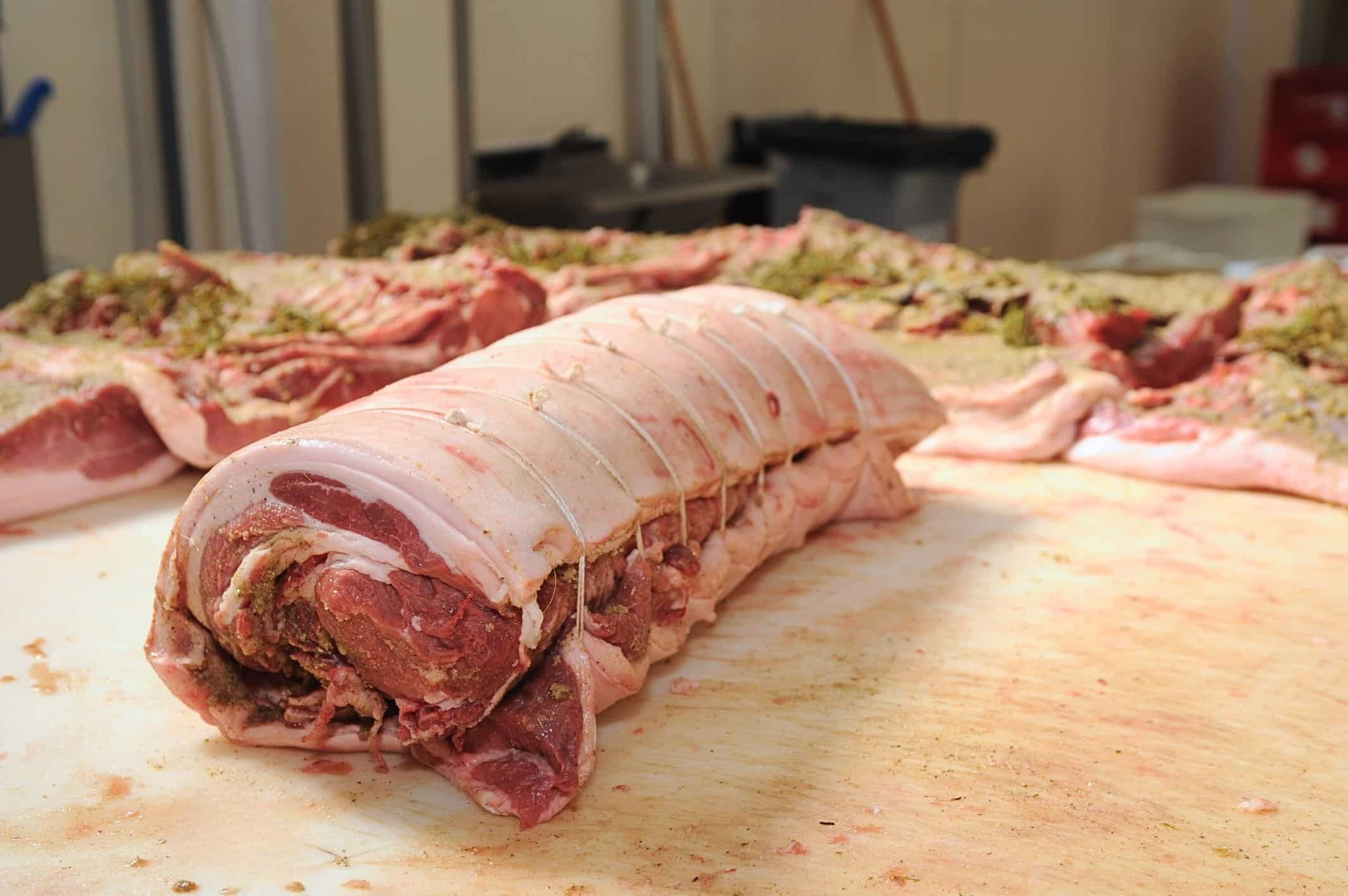 Carne di maiale arrotolata su tavolo.